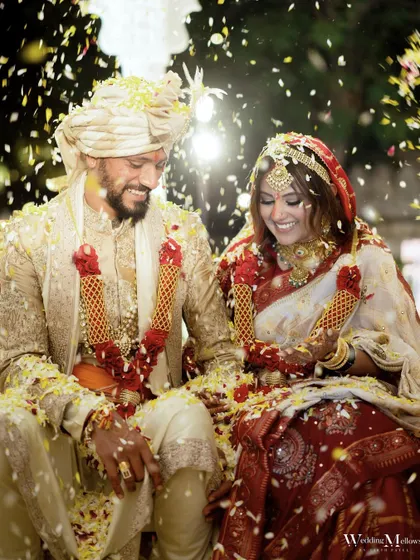 A joyous moment from the wedding ceremony, with the couple smiling as they are showered with flower petals. This photo is full of happiness and celebration.