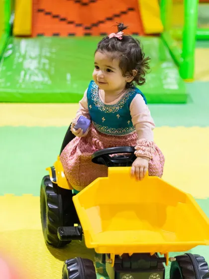 This adorable toddler is enjoying a ride on the mini tractor, perfect for our youngest visitors.