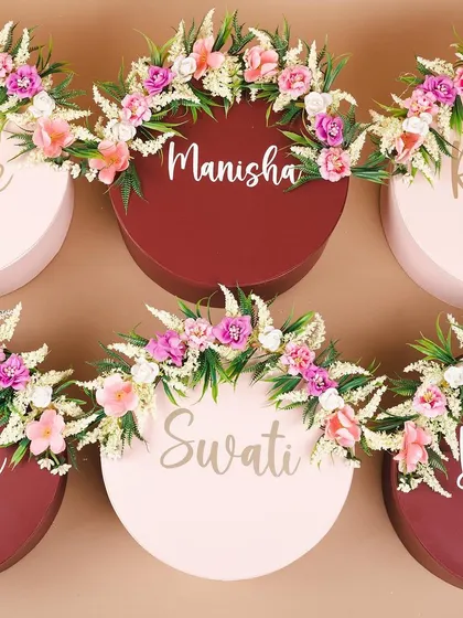 Personalized and floral-topped gift boxes for a bride's squad. We used a mix of pink and maroon boxes to match the wedding theme.