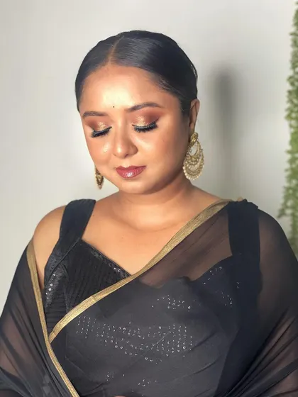 A classic party look featuring a black saree. I created a bronze smokey eye with a glossy lip and styled the hair in a sleek, elegant bun.