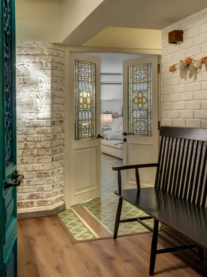The entryway to Alia Bhatt's home, featuring stained-glass doors and a white-washed brick wall. The design was about creating a simple, warm welcome, a space that felt personal from the moment you stepped inside.