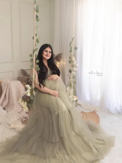A full-length view of the olive gown on the swing set. This shot showcases the entire dreamy, bohemian-inspired studio setup, which is one of my most requested styles.
