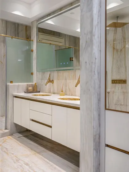 This view shows the master bathroom's well-considered layout, with a floating double vanity and a separate shower enclosure, all unified by the extensive use of white marble for a spa-like feel.