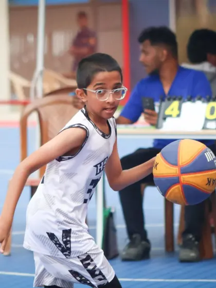 A young point guard brings the ball up the court, leading the offense. I develop leadership skills and basketball IQ in players from a young age.