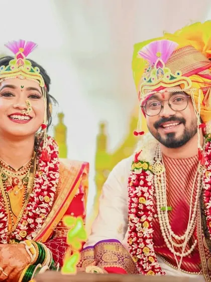 A bright and happy portrait of a couple during their wedding ceremony, both smiling for the camera.