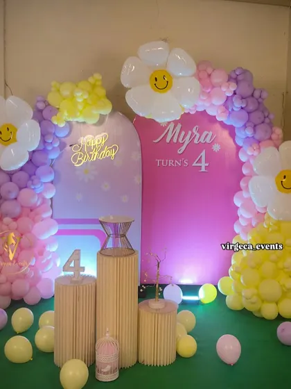 A cheerful and bright daisy-themed birthday party. The large smiley-face flower balloons add a touch of whimsy and fun to the decor.