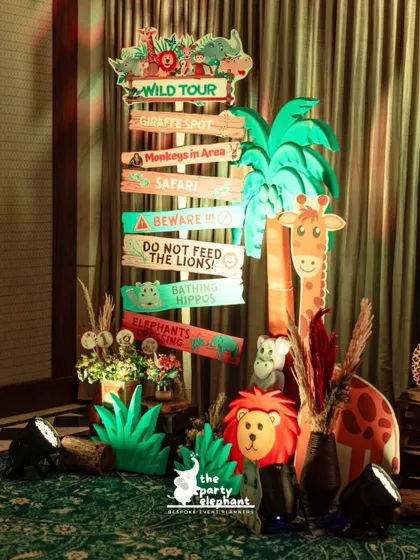 Another view of the jungle-themed directional signpost, surrounded by animal props and greenery, creating a fantastic photo opportunity for guests.