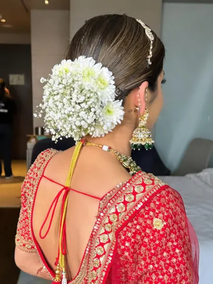 A beautiful, full bridal bun covered in a mix of white baby's breath and daisies. This is a fresh and lovely take on the traditional floral bun.