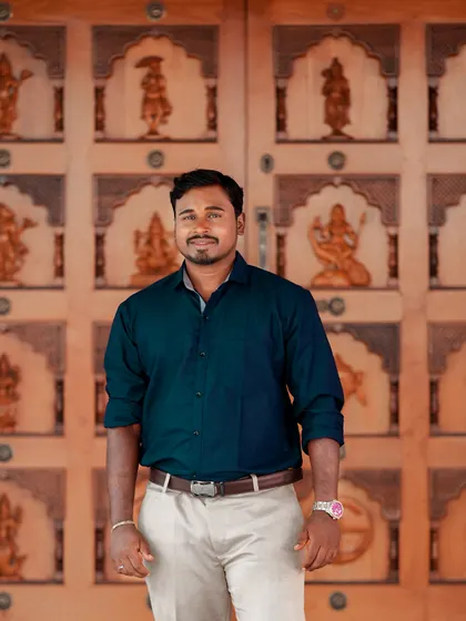 A simple and confident groom portrait in front of a traditional carved wooden door.