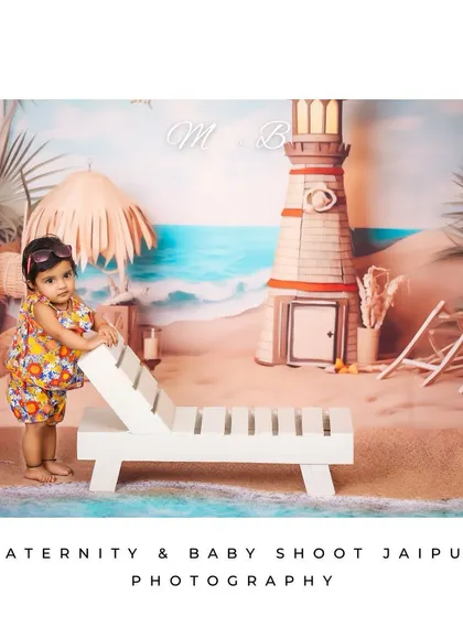 This little girl is ready for the sun in her cute sunglasses and floral outfit. The beach lounge chair and lighthouse prop complete this fun summer vacation theme.