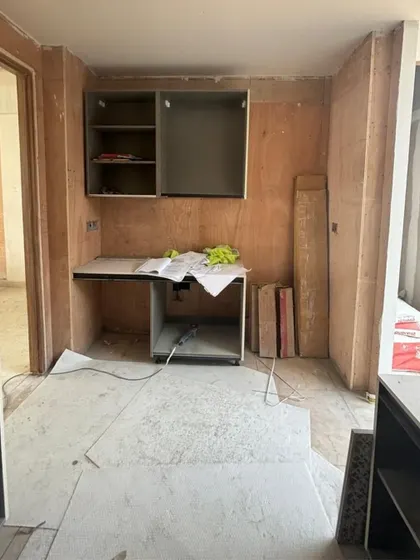 A work-in-progress shot of a kitchen installation, showing the plywood framework before the final finishes are applied.