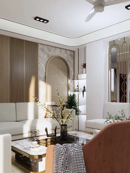 Sunlight enhances the warm and inviting atmosphere of this drawing room in Faridabad. The design balances neutral sofas with earthy-toned accent chairs, creating a layered look with varied textures in the wall panels and decor.