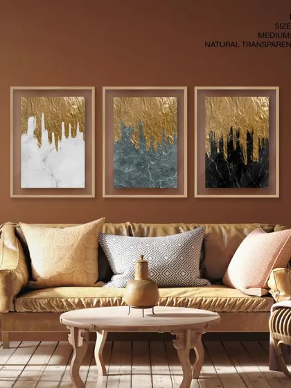 A warm and inviting living room featuring our set of three gold and marble abstract prints. The natural transparent frames provide a clean, modern look that lets the luxurious artwork shine.