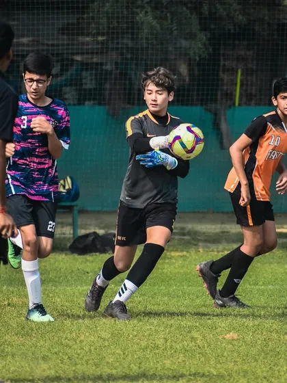 A goalkeeper gets ready to distribute the ball after making a save.