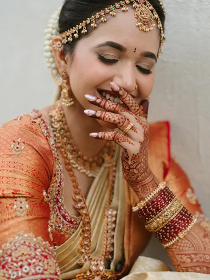 A laugh that lights up the room. This candid shot captures the pure joy of a bride on her wedding day, her radiant skin and happy smile being the best accessories.