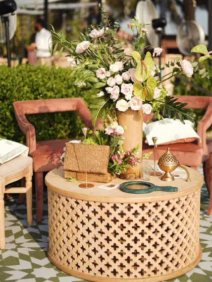 More details of the lounge area, showing the blend of rustic wood, soft textiles, and fresh flowers.