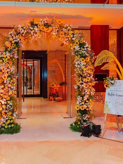 The grand entrance to the sunflower-themed Haldi, featuring a beautiful floral arch and themed decor elements that set a warm and welcoming tone.