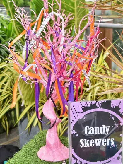 A creative "Candy Skewers" station where guests can pick their own treats from a decorative tree. This doubles as a fun activity and a party favor.