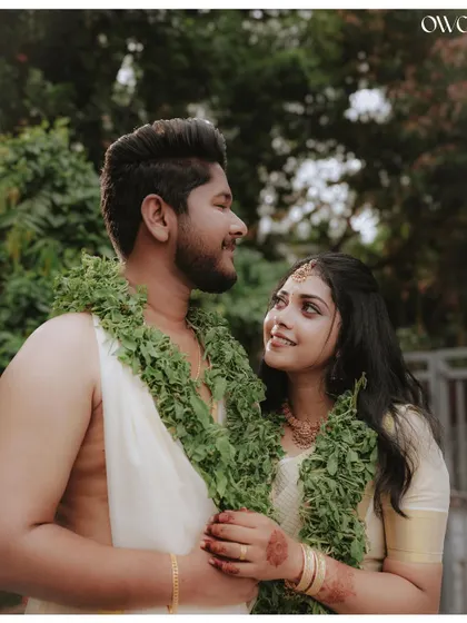 A classic portrait of a Kerala couple in traditional wedding attire, sharing a loving gaze.