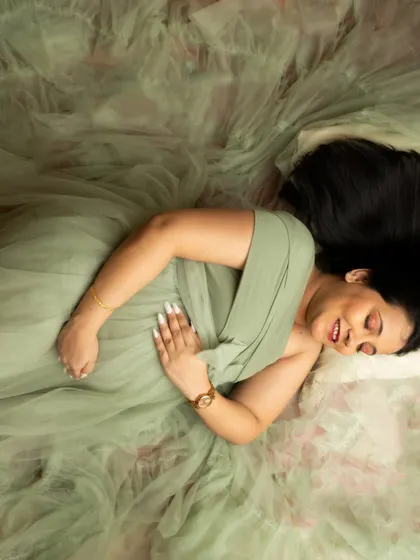 A peaceful top-down portrait in a soft green gown. This angle creates a beautiful composition, surrounded by the delicate tulle fabric.