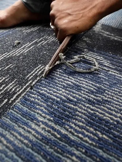 A worker carefully lays carpet tiles inside the mobile classroom. We used durable and colorful materials to create a welcoming and comfortable environment for the children.