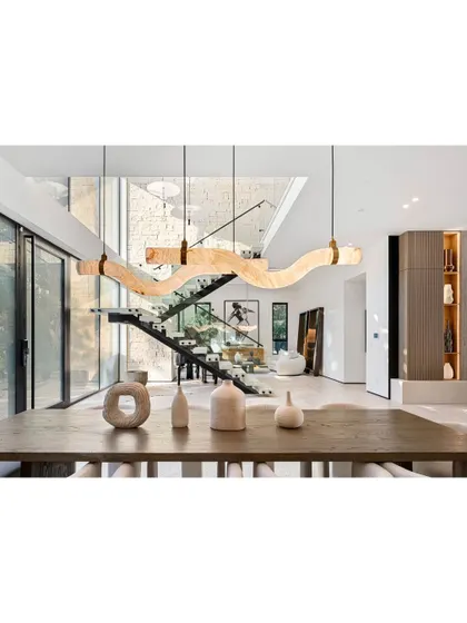 A close-up of a dining area with a stunning, sculptural wooden light fixture. This piece serves as the focal point of the room, demonstrating our belief in using lighting as art.