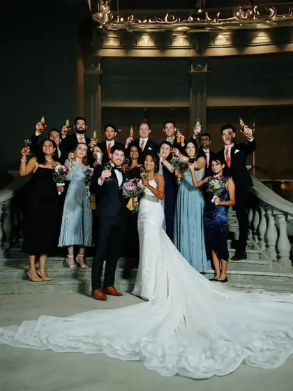 The happy couple, Samuel and Preeti, celebrating with their bridal party on the grand staircase after their Christian wedding ceremony.