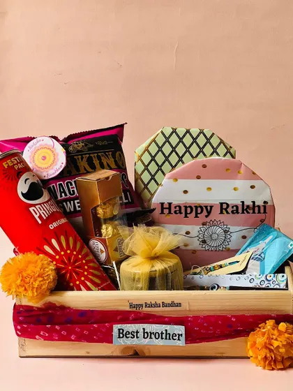 This Rakhi hamper is curated with Pringles, nachos, and other snacks, all tied together with a traditional red bandhani cloth.