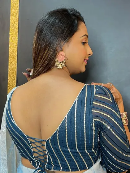 A look at the beautiful back design of the blouse and the soft hairstyle. Every detail matters when creating a complete look.