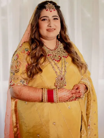 A full-length view of this bride's beautiful yellow wedding attire. The makeup is kept fresh and minimal to let the vibrant color of her outfit stand out.