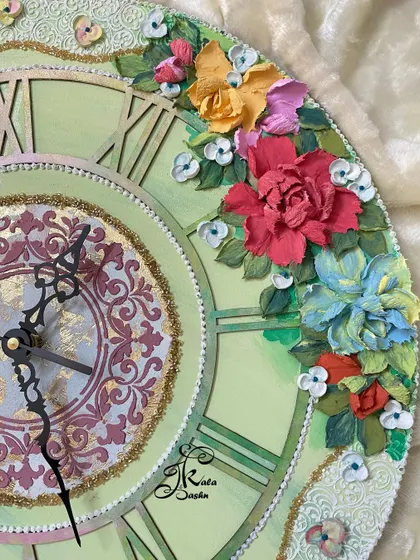 Detail shot of the light green clock. You can see how the red, blue, and yellow flowers are arranged to create a beautiful floral crescent, adding color and life to the piece.