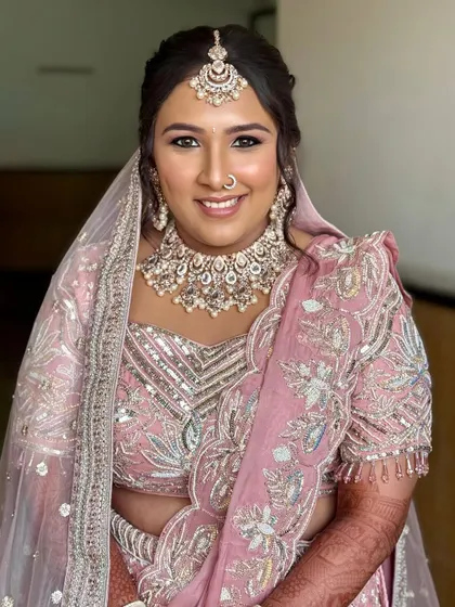 A perfect example of a modern pastel bride. This look features soft pink tones, a dewy base, and a beautifully detailed lehenga, creating a look that feels like a real-life desi Barbie.