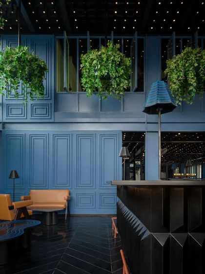 For this bar area, I created a cinematic, immersive mood using a deep blue palette on paneled walls and a faceted black granite bar. The design contrasts these cool, moody tones with the warmth of tan leather seating and a canopy of hanging plants, blending retro glamour with a touch of nature.