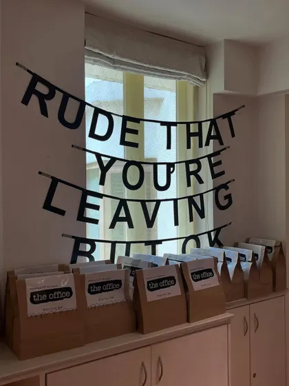 We included iconic inside jokes from the show, such as poorly labeled balloons, a "Rude that you're leaving" farewell banner, and a snack wall with the sign "Eat it, eat it".