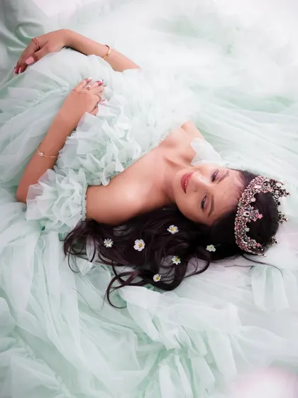 A duplicate of image 56, this dreamy overhead shot shows the mom-to-be lying in a cloud of mint green tulle, looking like a sleeping princess.