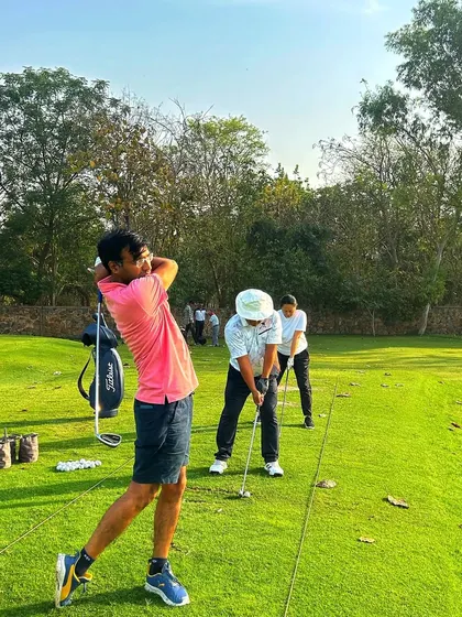 A young golfer shows off a powerful follow-through on the chipping green.