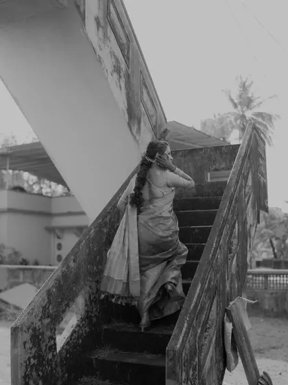 A black and white shot of the bride ascending a rustic staircase, creating a timeless and narrative-driven image.