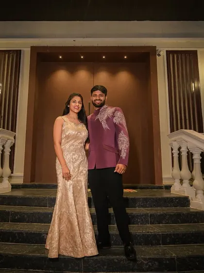 This full-length shot shows how the modern purple bandhgala jacket and classic black trousers create a sharp, formal look suitable for an engagement party or reception.