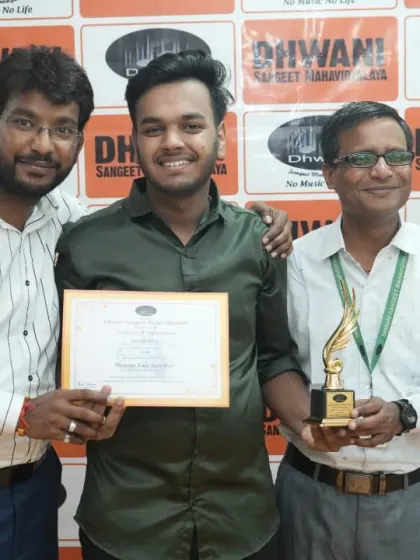 Two teachers present an award to their promising young student.