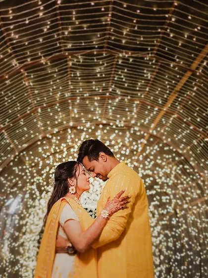 Lost in a universe of twinkling lights. This magical portrait places the couple inside a tunnel of fairy lights, creating an enchanting and romantic image that feels like a dream.