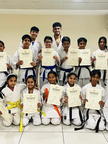 A proud group from our PFC and Purva Belmont dojos, showcasing a range of new belts from yellow to blue, representing the diverse levels of experience in our community.