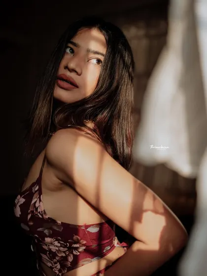This shot captures a soft, thoughtful expression, enhanced by the gentle light filtering through a window. It's a quiet and beautiful moment.