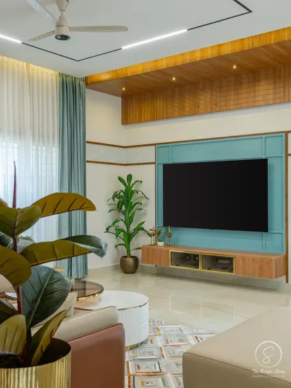 The TV unit in this living room features a calming blue back panel and a floating wooden console. The wooden false ceiling panel above adds warmth and architectural definition to the area.