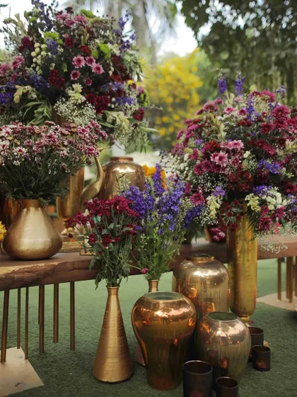 An explosion of colorful wildflowers in various brass vases, creating a rich and vibrant display.