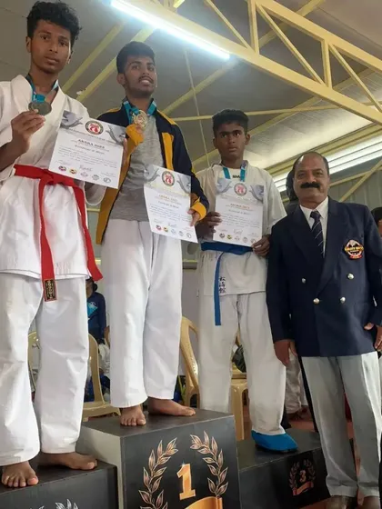 The winners' podium for the -63kg Kumite event, with my student securing the silver medal.