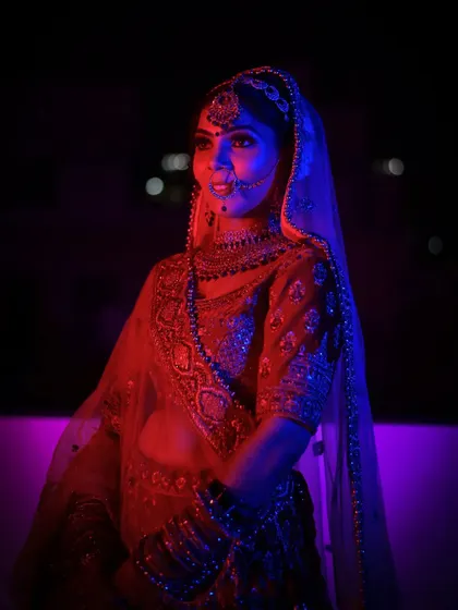 An artistic bridal portrait using dual-toned red and blue lighting to create a modern and moody effect.