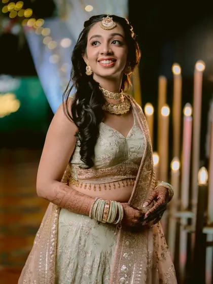 A candid shot of the bride looking away with a happy expression during her Sangeet night.