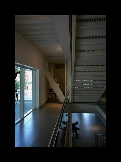 An interior view of the Museum of Art and Photography (MAP), showing the interplay of different levels and the flow of space. The design uses light and volume to guide visitors through the galleries, creating a journey of discovery.