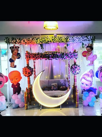 A slightly different angle of the mixed-character baby shower setup, showing the arrangement of props around the central swing and moon.