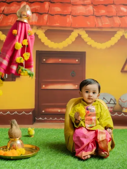 Capturing the baby's curiosity as he holds a prop. The vibrant colors of the backdrop and marigold flowers make these photos feel full of life.